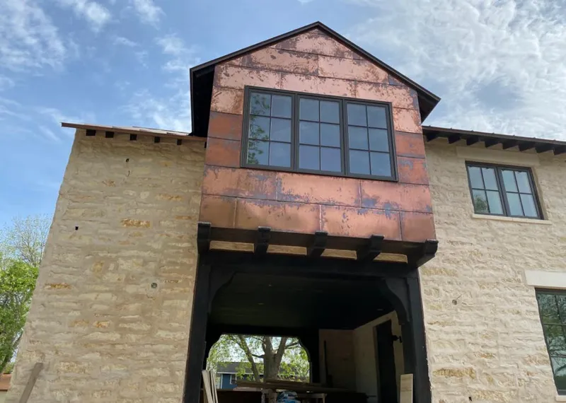 Copper metal panel facade on a stone building for Roof Repair in Freeport